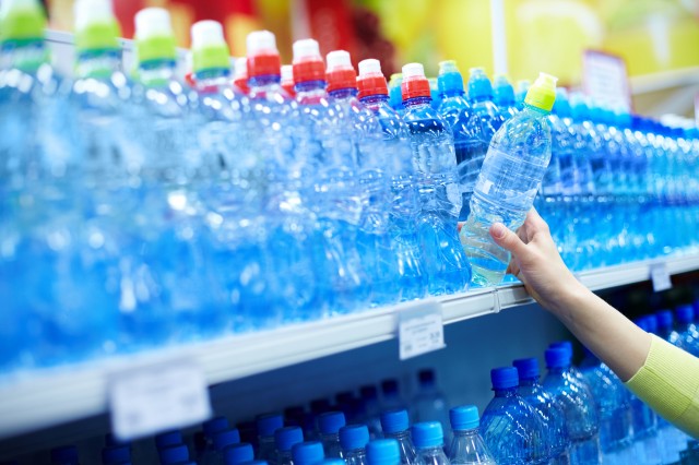 close-up-of-female-choosing-good-mineral-water-in-a-shop-SBI-325331472.jpg